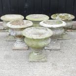 A set of six reconstituted stone garden urns,