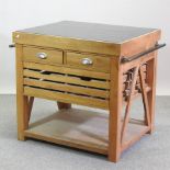 A light oak kitchen island, with a black granite top,