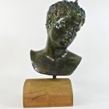 A plaster bust of a man, on a wooden plinth base,