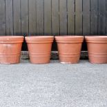 A set of four large terracotta style garden pots,