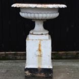 A large 19th century painted cast iron garden urn, of campana shape, on a pedestal base,