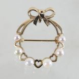 A 9 carat gold and seed pearl brooch, in the form of a wreath tied with a bow,