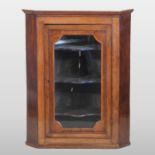A George III oak hanging corner cabinet, with a glazed door,