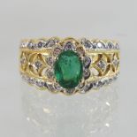 An 18 carat gold emerald and diamond cluster ring