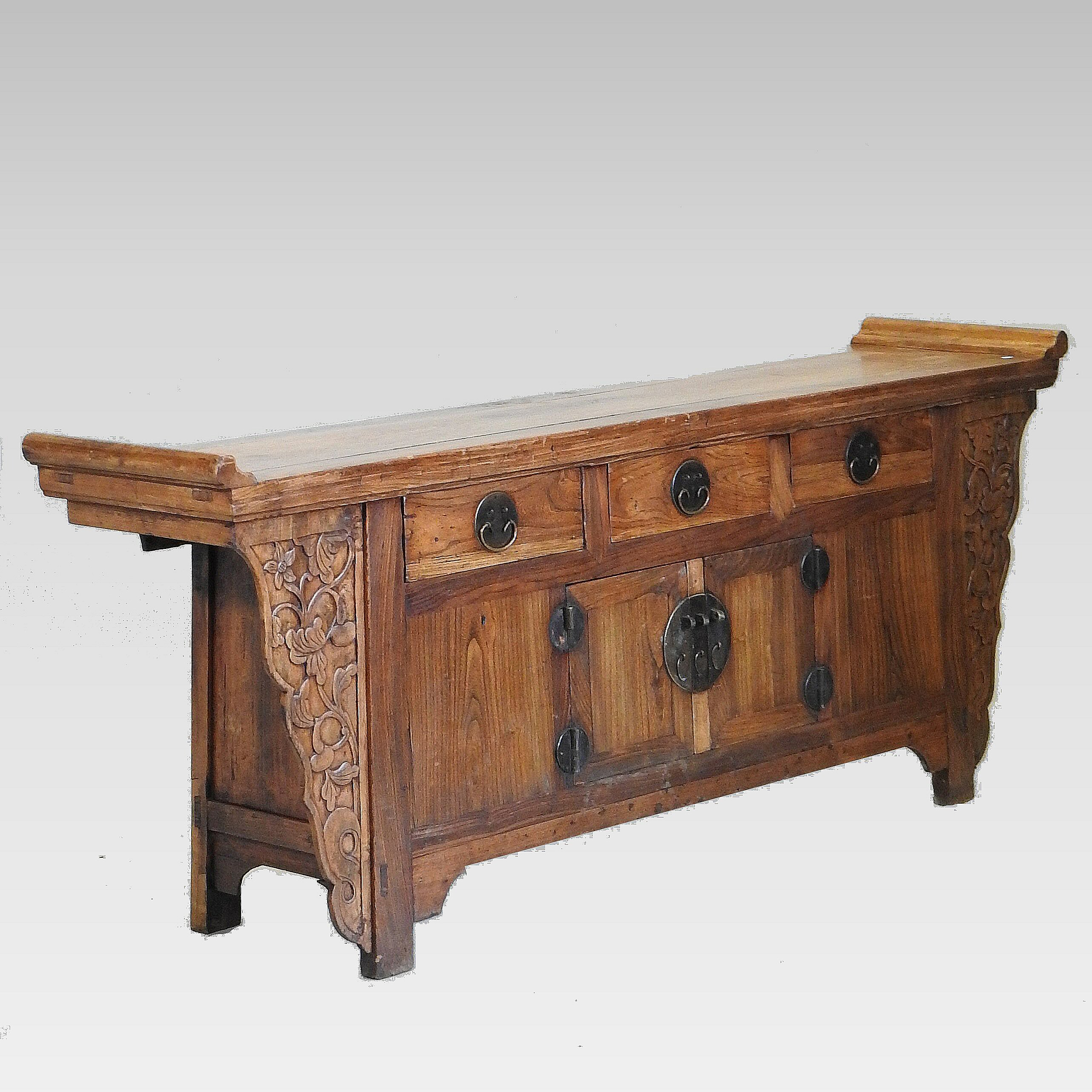 A Chinese carved hardwood altar cabinet, containing three short drawers above cupboard doors,