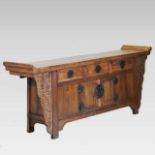 A Chinese carved hardwood altar cabinet, containing three short drawers above cupboard doors,