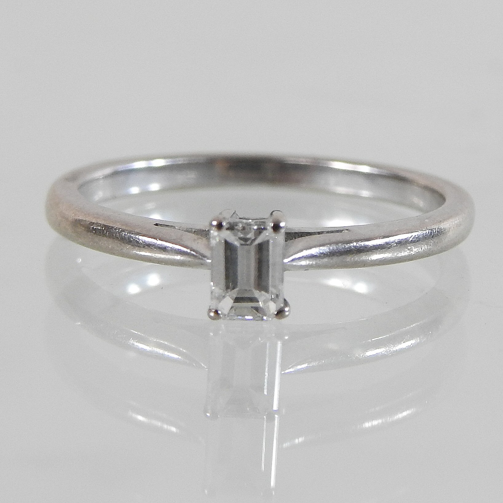 An 18 carat gold solitaire diamond ring, set with a single baguette cut stone, approximately 0.