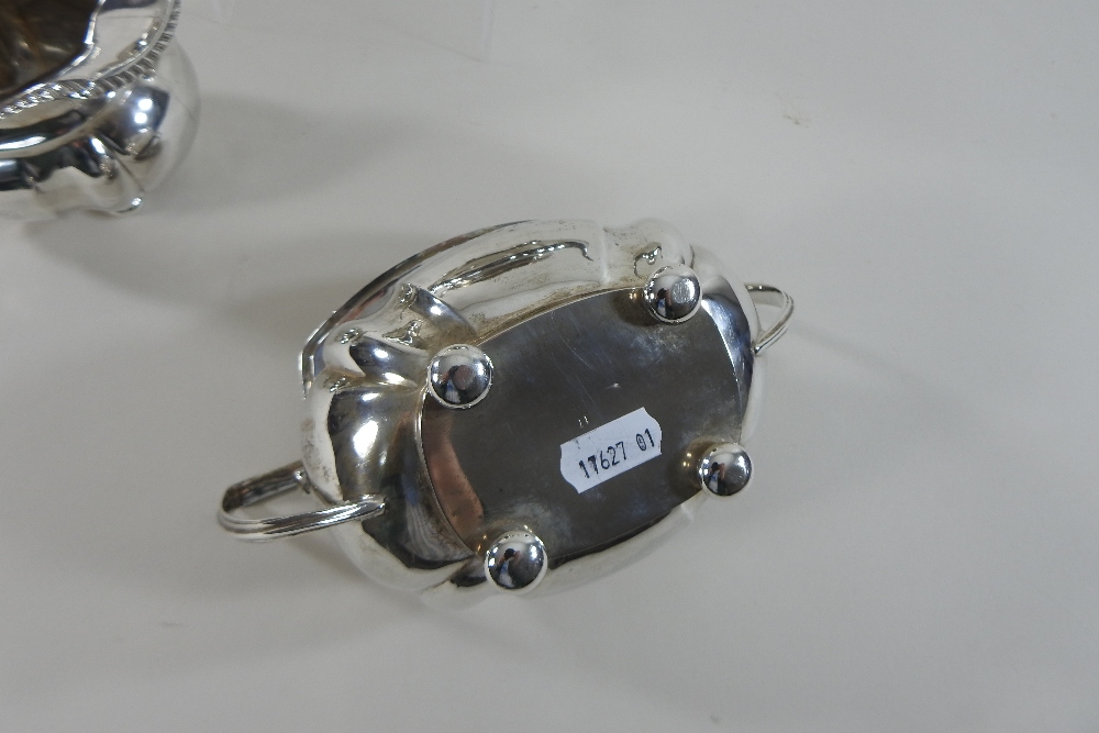 An early 20th century silver three-piece tea service, comprising a teapot, sugar bowl and cream jug, - Image 8 of 12