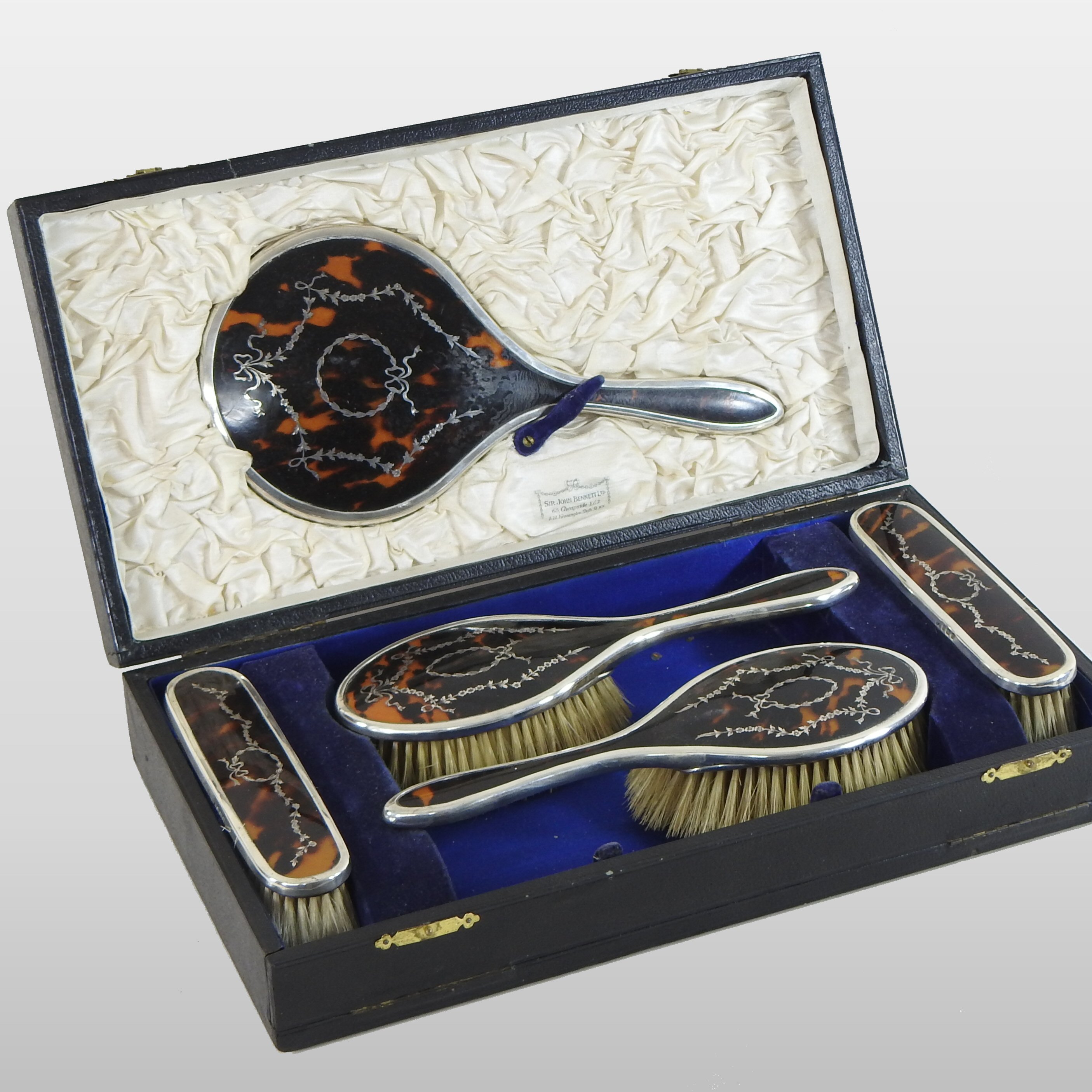 An early 20th century silver and tortoiseshell dressing table set, with pique work decoration,