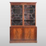 A 19th century mahogany bookcase, enclosed by a pair of glazed doors with beaded decoration,