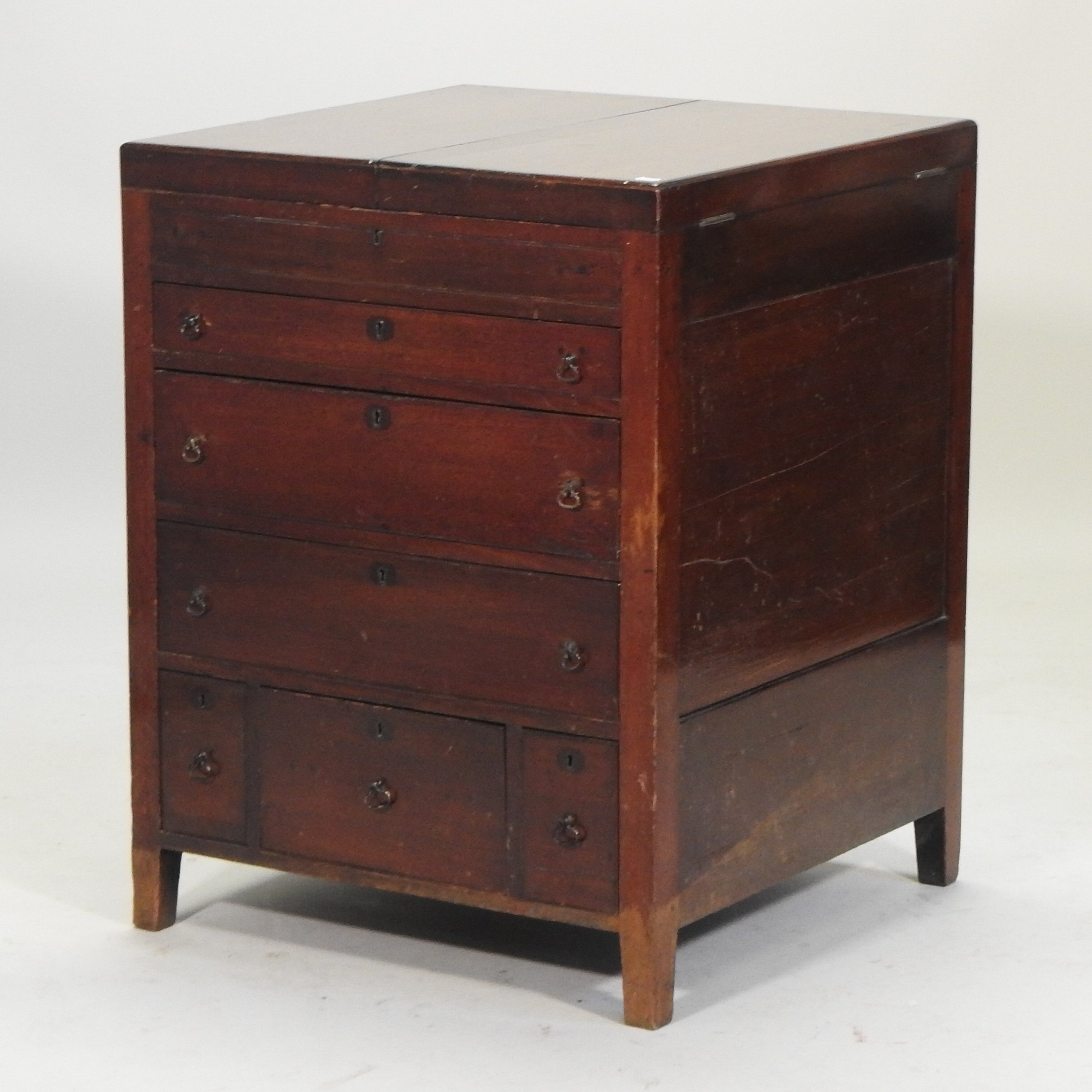 A George III mahogany enclosed washstand, with a dual hinged top and cupboards below,