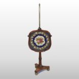 A late Regency rosewood needlepoint pole screen, on fluted column and a triform base,