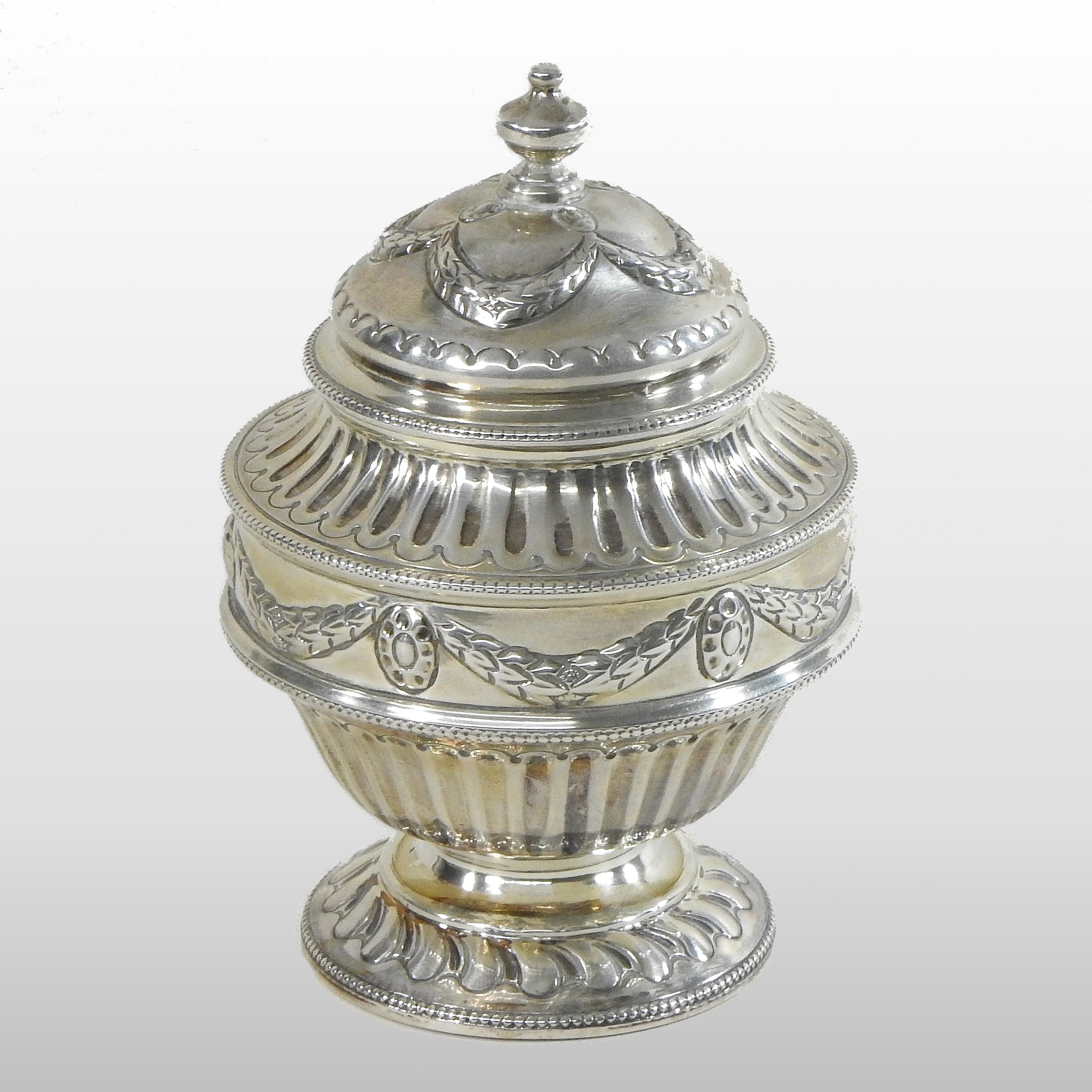 A late Victorian silver tea canister, the lid decorated with swags above a half gadrooned body,