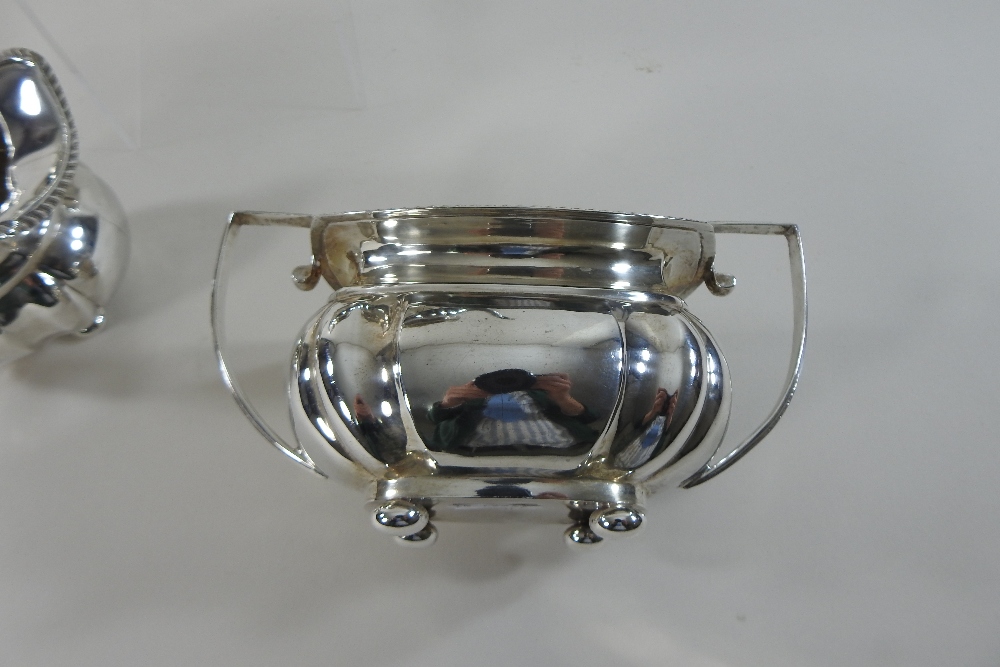 An early 20th century silver three-piece tea service, comprising a teapot, sugar bowl and cream jug, - Image 9 of 12