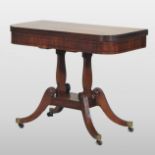 A Regency mahogany and ebony strung folding tea table, with a hinged D shaped top,