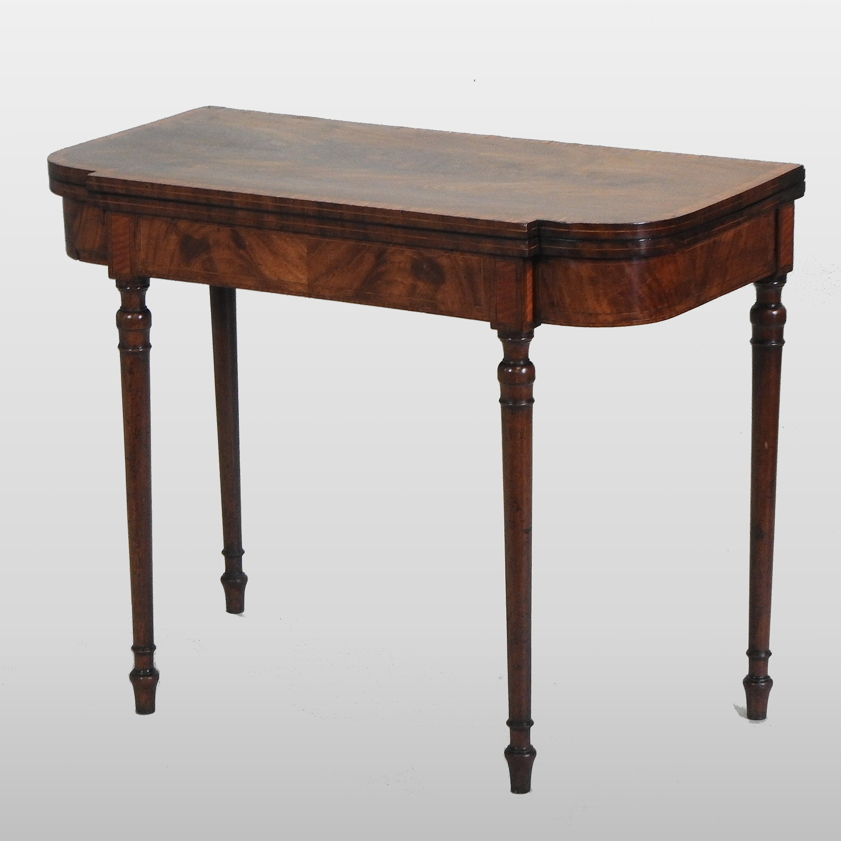 A George III mahogany and satinwood crossbanded folding card table, with a hinged breakfront top,
