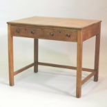 An early 20th century Cotswold style light oak writing table, containing a pair of short drawers,