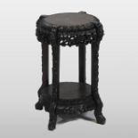 An early 20th century Chinese hardwood two tier jardiniere stand, with floral carved decoration,