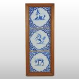 A set of three Delft tiles, mounted in a pine frame,