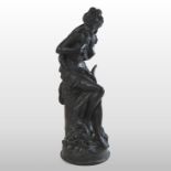A bronzed figure of a girl, holding doves,