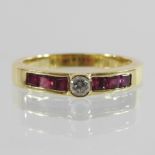 An 18 carat gold diamond ring, with channel set ruby shoulders,