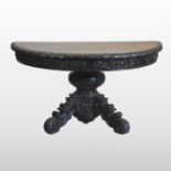 A Victorian carved oak half round side table, on a scrolled base,