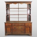 An 18th century oak dresser, with an open plate rack, the base fitted with drawers,