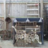 An ornate iron gate, 113 x 82cm, together with another, a pair of bench ends, a grain hopper,