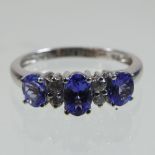 An 18 carat gold tanzanite and diamond seven stone ring, boxed,