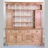 A large pine dresser, with drawers and cupboards below,