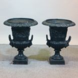 A pair of Victorian black painted cast iron garden urns, of campana shape,