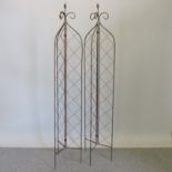 A pair of rusted metal garden spires,