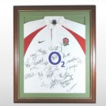 A 2003 England World cup rugby shirt, signed by the players, in a presentation glazed display case,