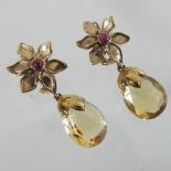 A pair of 9 carat gold gem set earrings, in the form of flowers,