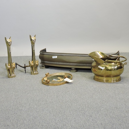 A pair of brass andirons in the form of cats, together with a fender, 106cm,