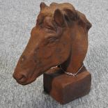 A rusted cast iron bust of a horse's head,