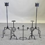 A pair of wrought iron candle sticks, 94cm high,