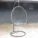 A hanging garden chair, on a metal stand,