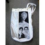 A 'Rosamunda' PVC and linen duffle bag with silver chain drawstring and black and white images.