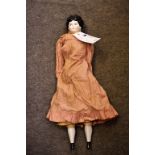 A 19th century china shoulder head doll with blue painted eyes, black moulded centre parted hair,