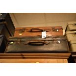A pair of vintage leather suitcases, one tan and one black (2)