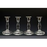 A set of four cut glass table candlesticks, c.1900, the serpentine cut rims over hexagonal cut