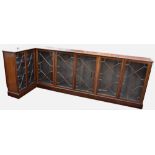 An L-shaped mahogany dwarf glazed bookcase, 1920s, the moulded top over seven 13-pane astragal