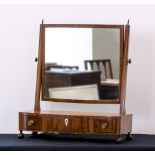 A George IV mahogany swing mirror, with bowfront box base with three drawers, on ball feet.