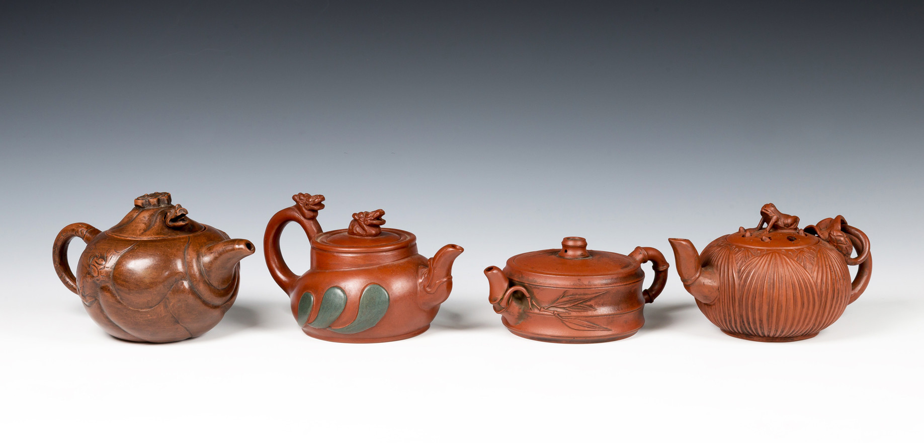 Four Chinese Yixing teapots, one of squat horizontal fluted form with bamboo design handle, the