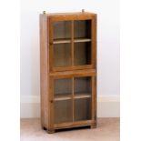 A mid-century limed oak glazed bookcase by Heals, with Heals ivorine label inset to inside of