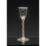 An 18th century airtwist wine glass, soda glass, the bell bowl on a plain, three ply airtwist stem