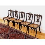 A set of five Regency ebonised beech wood lyre back neo-classical side chairs, the plain, curved top