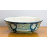 A Minton Art Nouveau style wash bowl, shallow circular form with everted rim, glazed in grey-blue