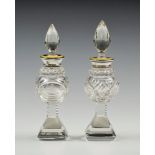 A near pair of Edwardian cut glass, silver & enamel perfume bottles, the silver and yellow guilloche